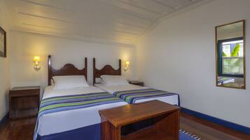 A double bed with a wooden headboard, two bedside tables with lamps, and a mirror on the wall.