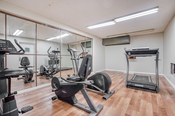 A gym with cardio machines, weight equipment, and a mirrored wall. - OYO Hotel Brownwood Hwy 67 (Brownwood)