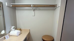 A bathroom with a sink, mirror, towel, stool, and a towel rack. - Extend-a-Suites Phoenix (Phoenix)