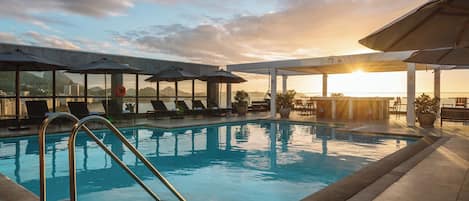 Utomhuspool, parasoller och solstolar