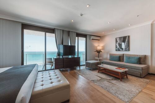 Suite, uitzicht op zee, aan het strand | 1 slaapkamer, een minibar, een kluis op de kamer, een bureau