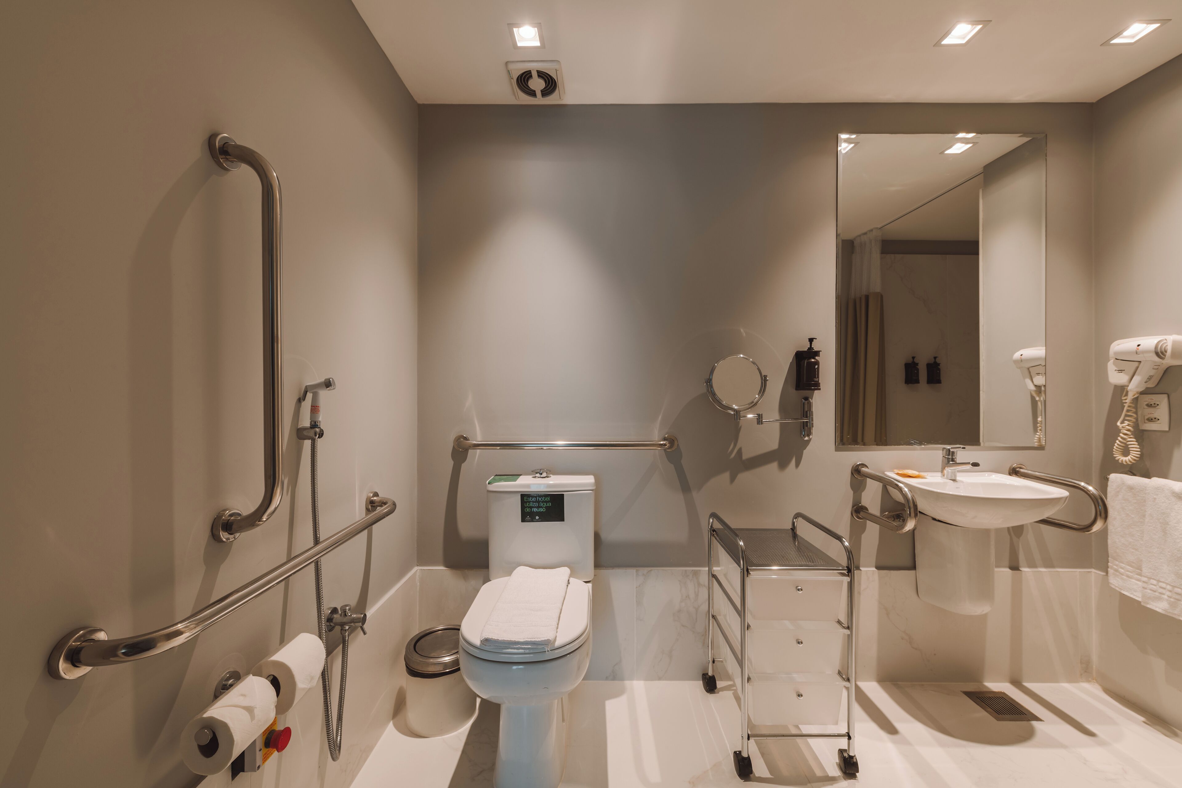 Un baño moderno con inodoro, bidé, secamanos y lavamanos.