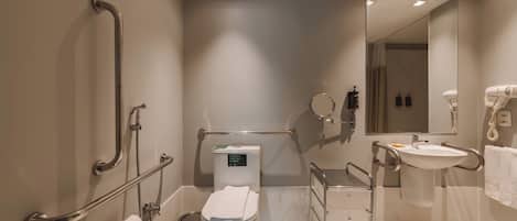 Un baño moderno con inodoro, bidé, secamanos y lavamanos.