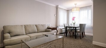 Suíte júnior, 1 cama Queen, suíte, vista para a cidade | Sala de estar | TV 40 polegadas com canais via satélite