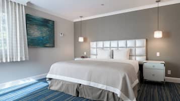 Een netjes ingerichte hotelkamer met een groot bed, nachtkastje en een aan de muur hangend schilderij.