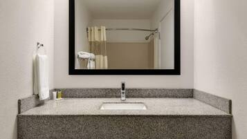 Baño con lavamanos de granito, espejo y toallero.