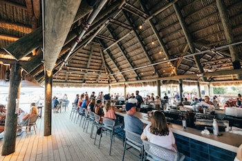 An outdoor dining area with tables and chairs, a fire pit, and string lights. at Beach House Resort Hilton Head