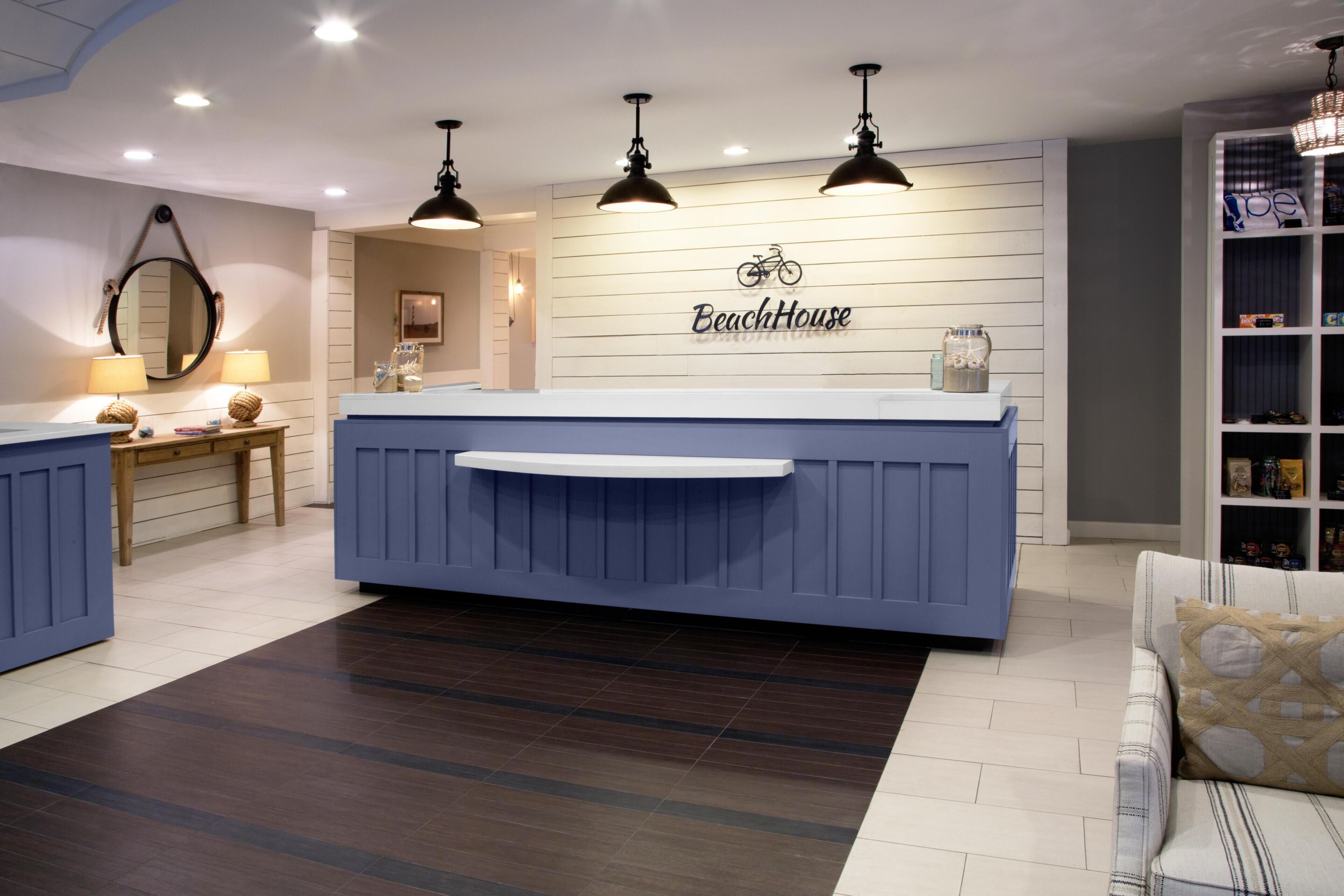 A reception area with a blue counter, a bicycle logo, and a bookshelf with various items.