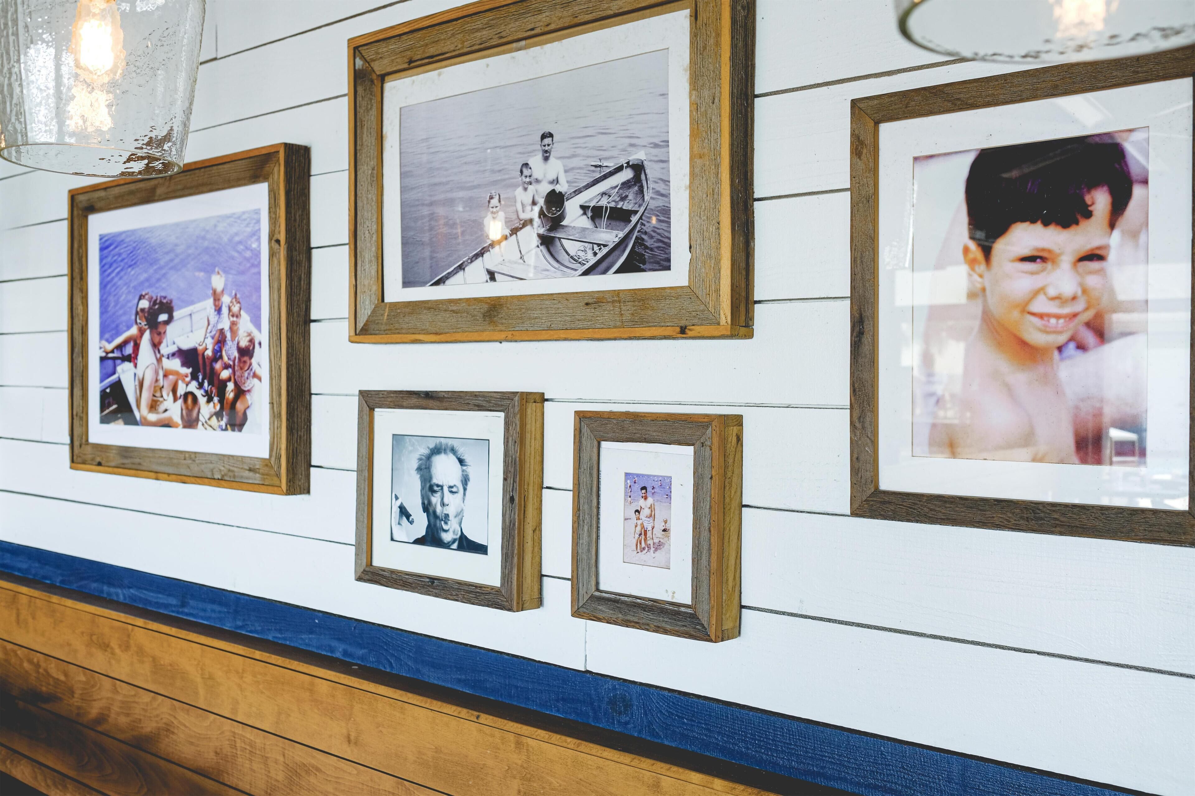 A wall with multiple framed photographs.