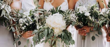 Une scène de mariage où les demoiselles d’honneur tiennent des bouquets.