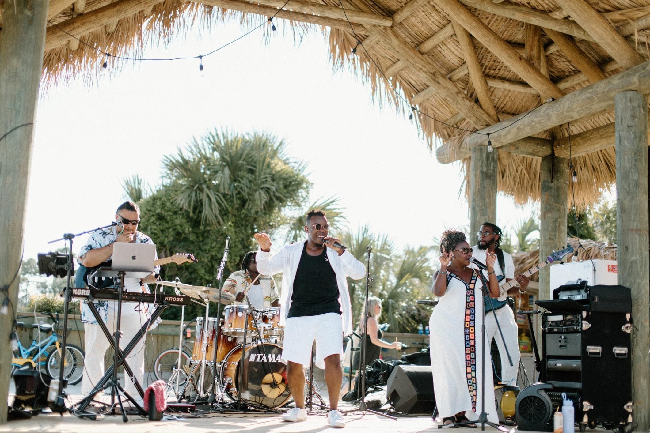 A band performing on an outdoor stage with musical instruments and equipment.
