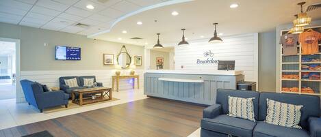 A reception area with a counter, sofas, and a coffee table.