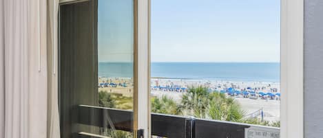 A view from a balcony overlooking a beach with a sign indicating VIP front seat availability.