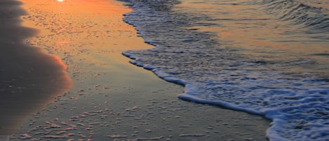Na praia, areia branca, prática de vôlei de praia, bar na praia