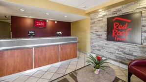 A reception area with a counter, a sign indicating free Wi-Fi, and a Red Roof Inn sign. - Red Roof Inn Columbus East - Reynoldsburg (Columbus)