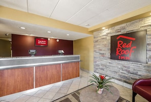 A reception area with a counter, a sign indicating free Wi-Fi, and a Red Roof Inn sign.