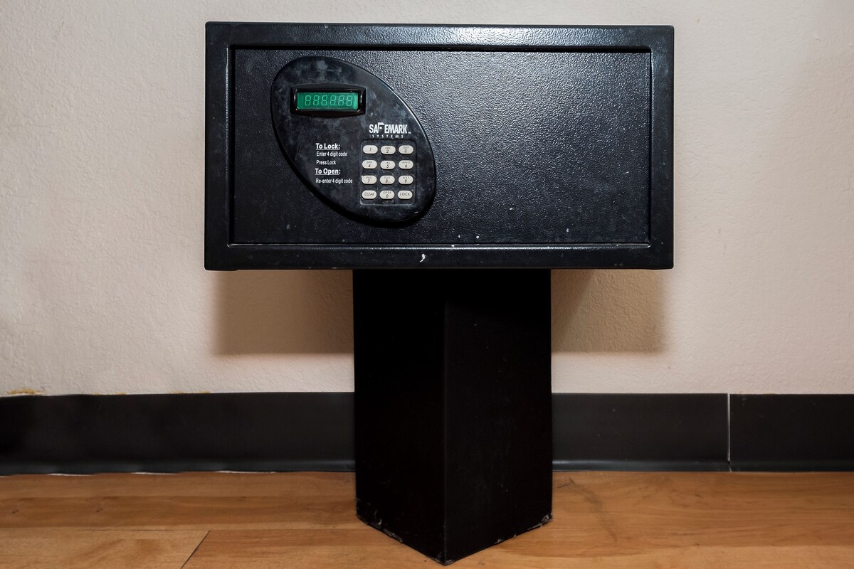 A black electronic device with a keypad and a digital display, mounted on a black stand.