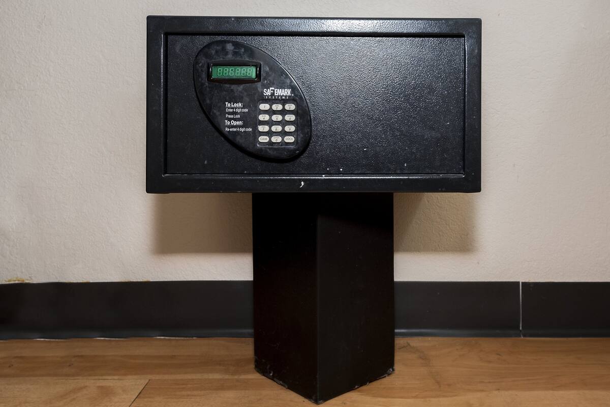 Un clavier électronique noir, fixé sur un piédestal noir, est adossé à un mur.
