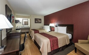 A hotel room with two beds, a desk, a chair, a mirror, and a television. - Red Roof Inn Columbus East - Reynoldsburg (Columbus)