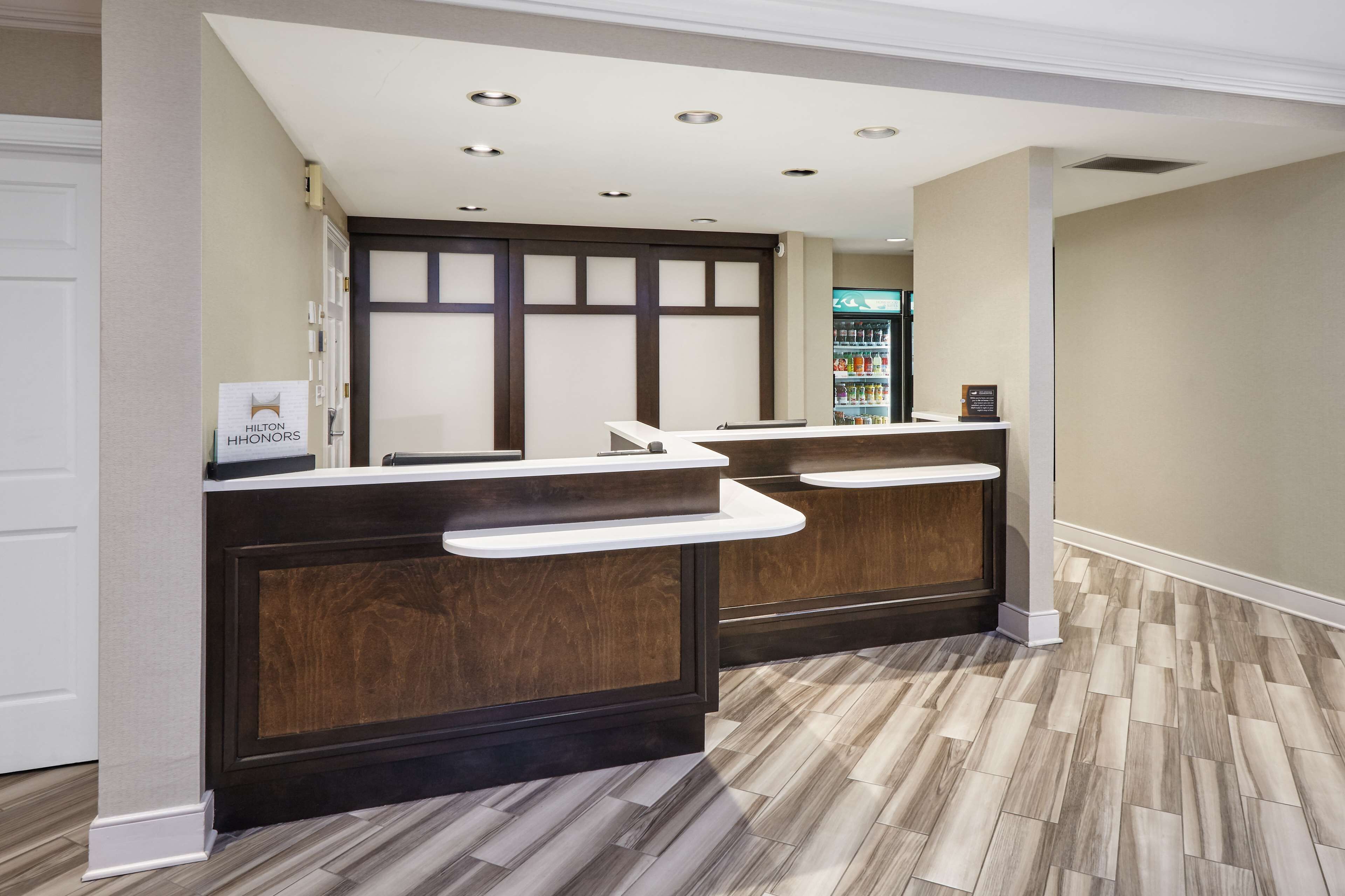 Zona de recepción con dos mostradores, un minibar y un refrigerador al fondo.