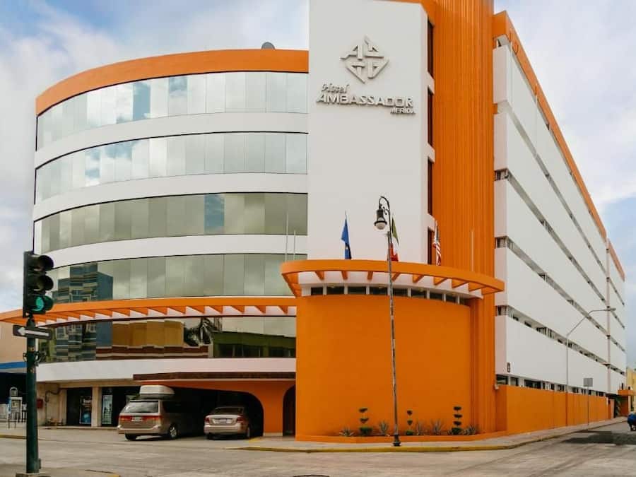 A modern hotel with a curved facade, multiple floors, and a prominent orange and white color scheme.