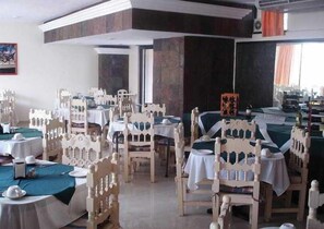 A dining area with multiple tables and chairs, arranged in rows. - Ambassador (Mérida)