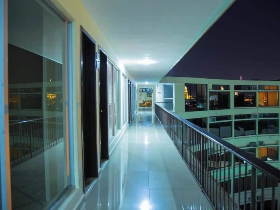 Un corridoio con porte e finestre in vetro che dà su un balcone con vista su altri edifici.