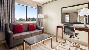 Una habitación de hotel moderna con un sofá, un escritorio y una silla.