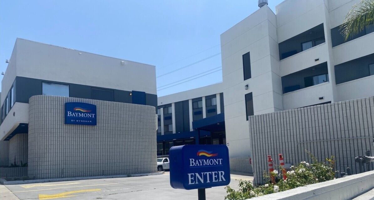Un edificio moderno con el letrero 'Baymont' y una señal que indica 'ENTRADA'.