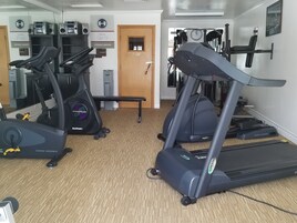 A fitness center with treadmills, stationary bikes, and weight machines.