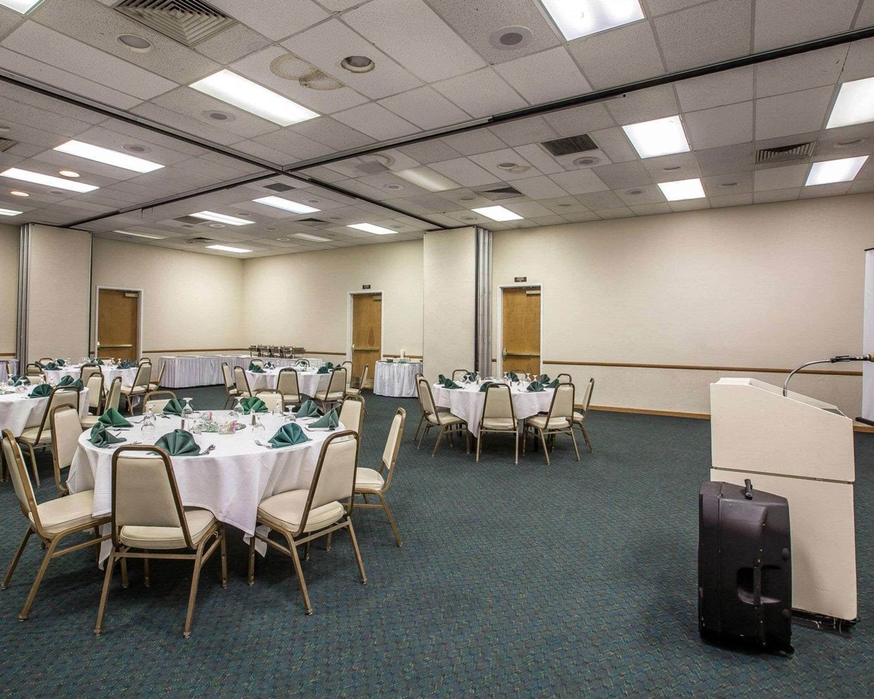 A conference room with round tables, chairs, and a podium.