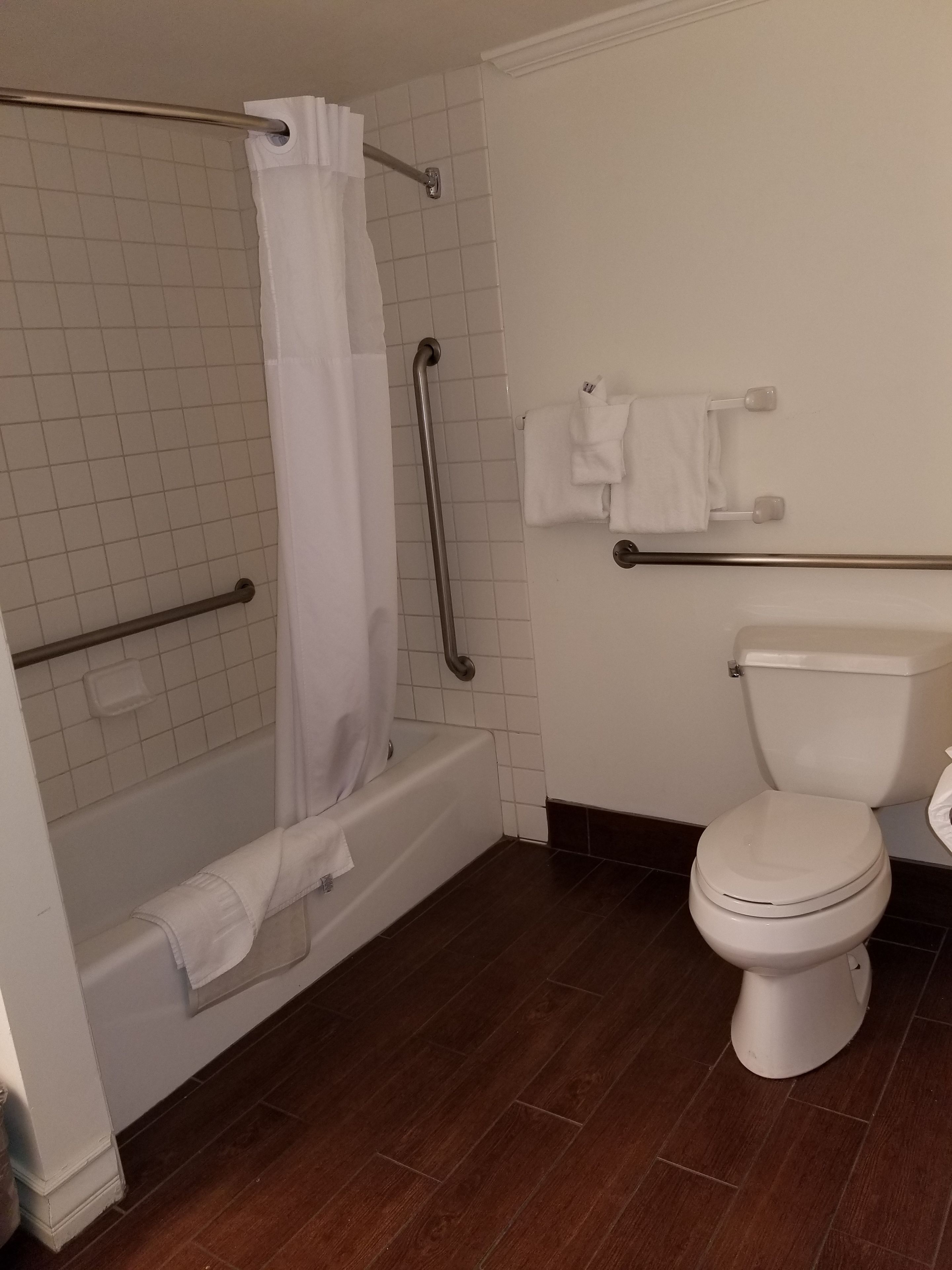 A bathroom with a bathtub, a toilet, and a shower area.