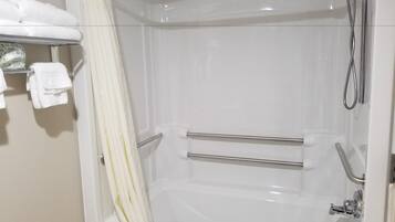 A white bathtub with a showerhead and grab bars.