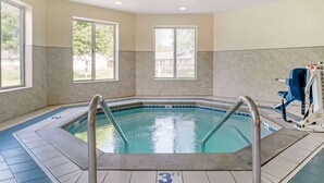 A swimming pool with a 3 FT depth marker, surrounded by a tiled floor, and large windows providing natural light. - Best Western Beacon Inn (Grand Haven)