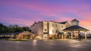 A multi-story hotel with a covered entrance and a parking lot. - Best Western Beacon Inn (Grand Haven)