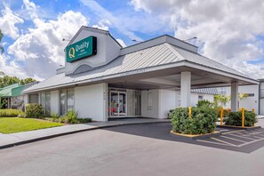 A hotel entrance with a sign reading 'Quality Inn,' a covered parking area, and a registration desk. - Quality Inn Downtown Stuart (Stuart)