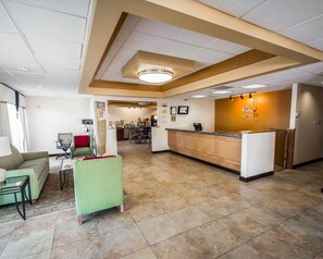 A hotel lobby with a reception desk, seating area, and a view into the dining area. - Quality Inn Downtown Stuart (Stuart)