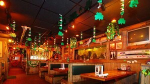 A restaurant with booths, a bar area, and a television screen. - Quality Inn Downtown Stuart (Stuart)