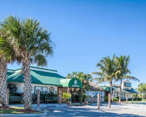 A hotel with a green roof, palm trees, and a sign that reads 'Quality Inn.' - Quality Inn Downtown Stuart (Stuart)