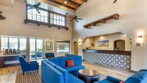 A spacious lobby with a high ceiling, a reception desk, and seating areas. - Comfort Inn & Suites Orange County John Wayne Airport (Santa Ana)