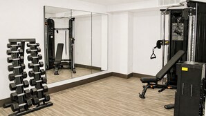 A gym with a mirror, weight rack, and exercise equipment. - The Cairn Hotel, an Ascend Collection Hotel (Cedar City)