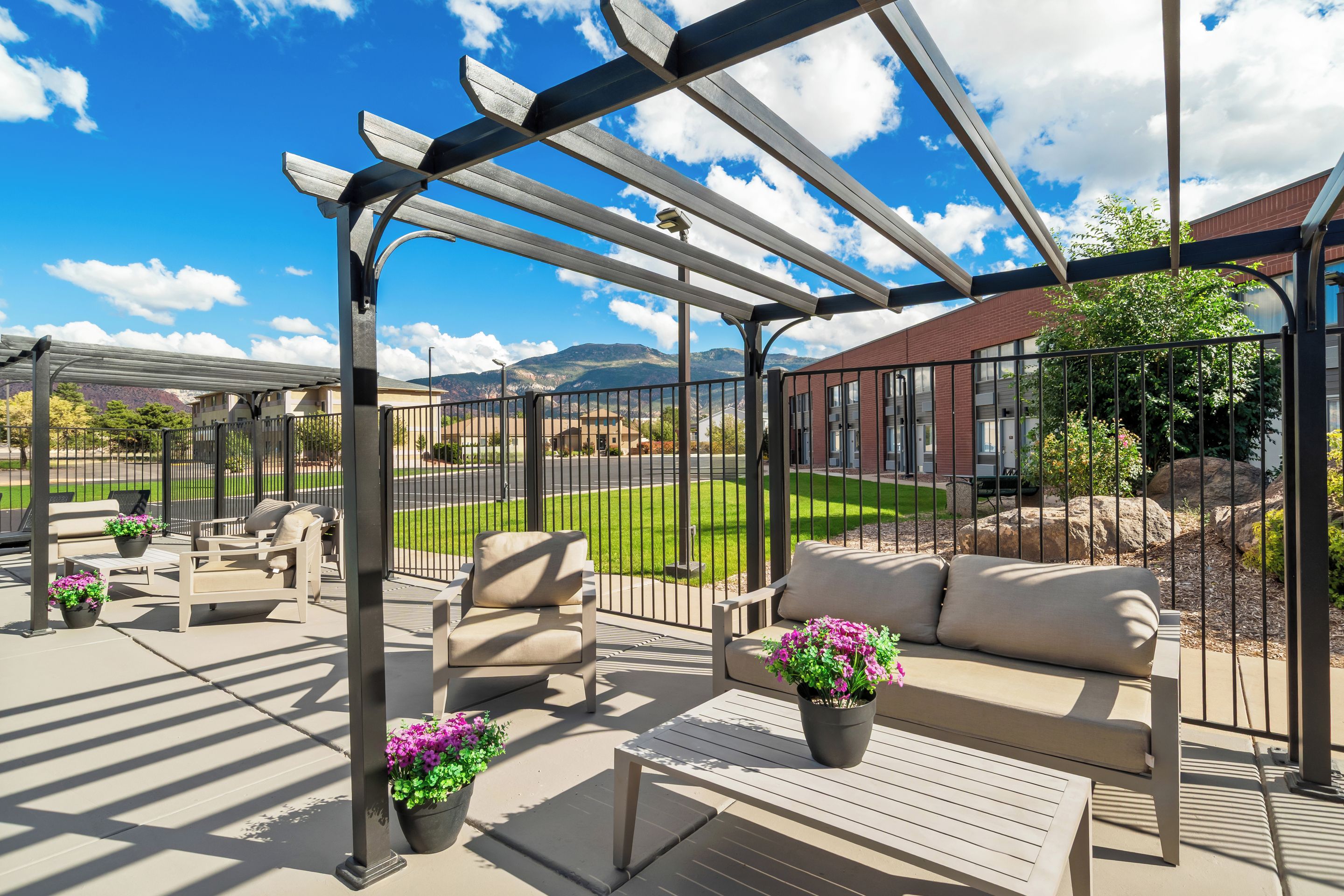 A covered outdoor seating area with a view of a mountain range.