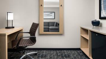 A modern office space with a desk, chair, and a black cabinet.