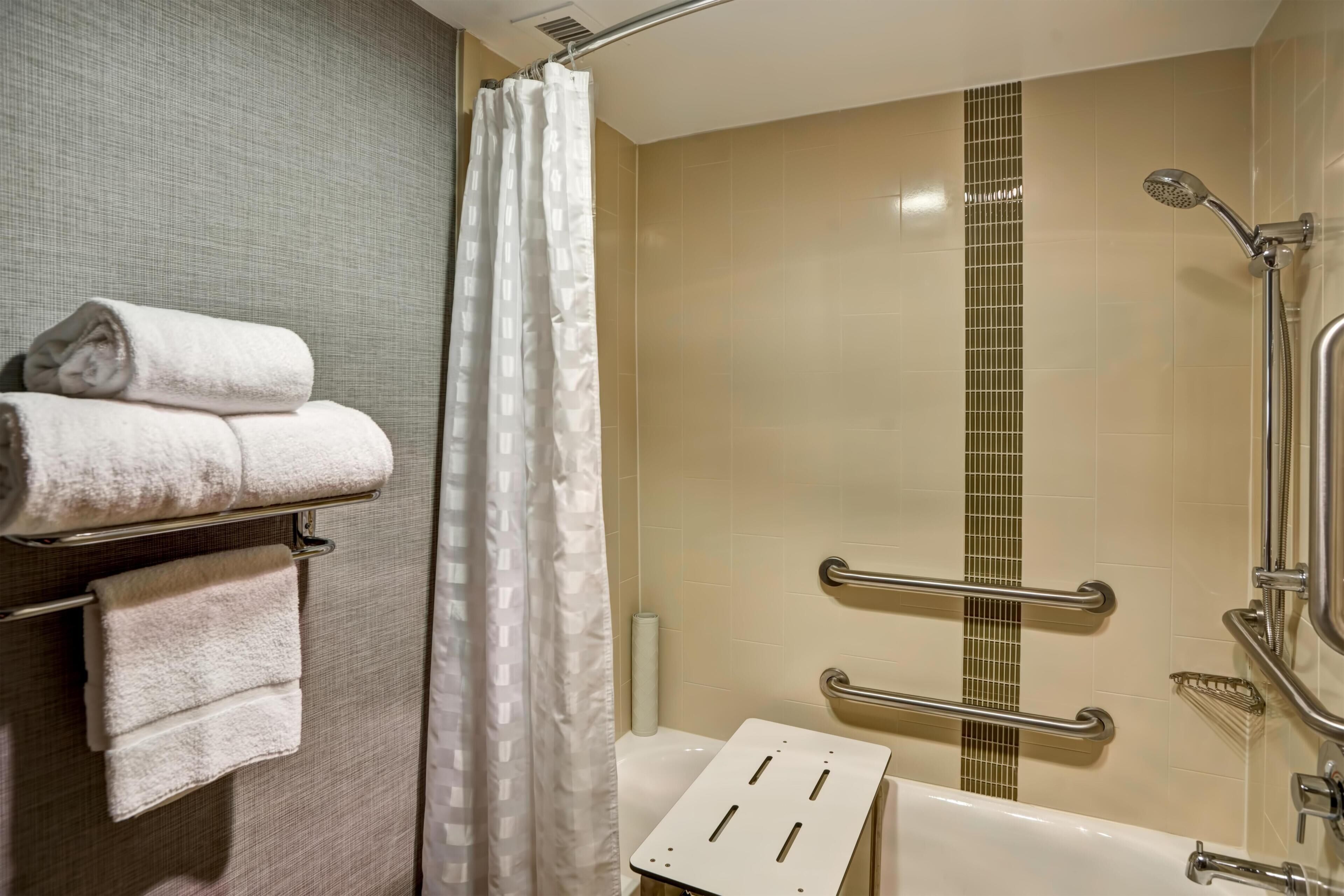 Une salle de bain équipée d’une douche, d’une baignoire et d’un porte-serviettes avec des serviettes.