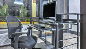 Una silla de oficina moderna con un escritorio, un monitor de computadora y un teclado.
