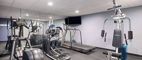 A gym with treadmills, elliptical machines, and weight equipment.