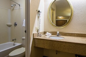 Enjoy a clean and functional bathroom with a single sink, granite countertop, mirror, and handheld showerhead.
