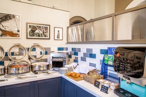 A buffet setup with various food items, a coffee machine, and decorative wall art. - Park House Hotel (Shifnal)