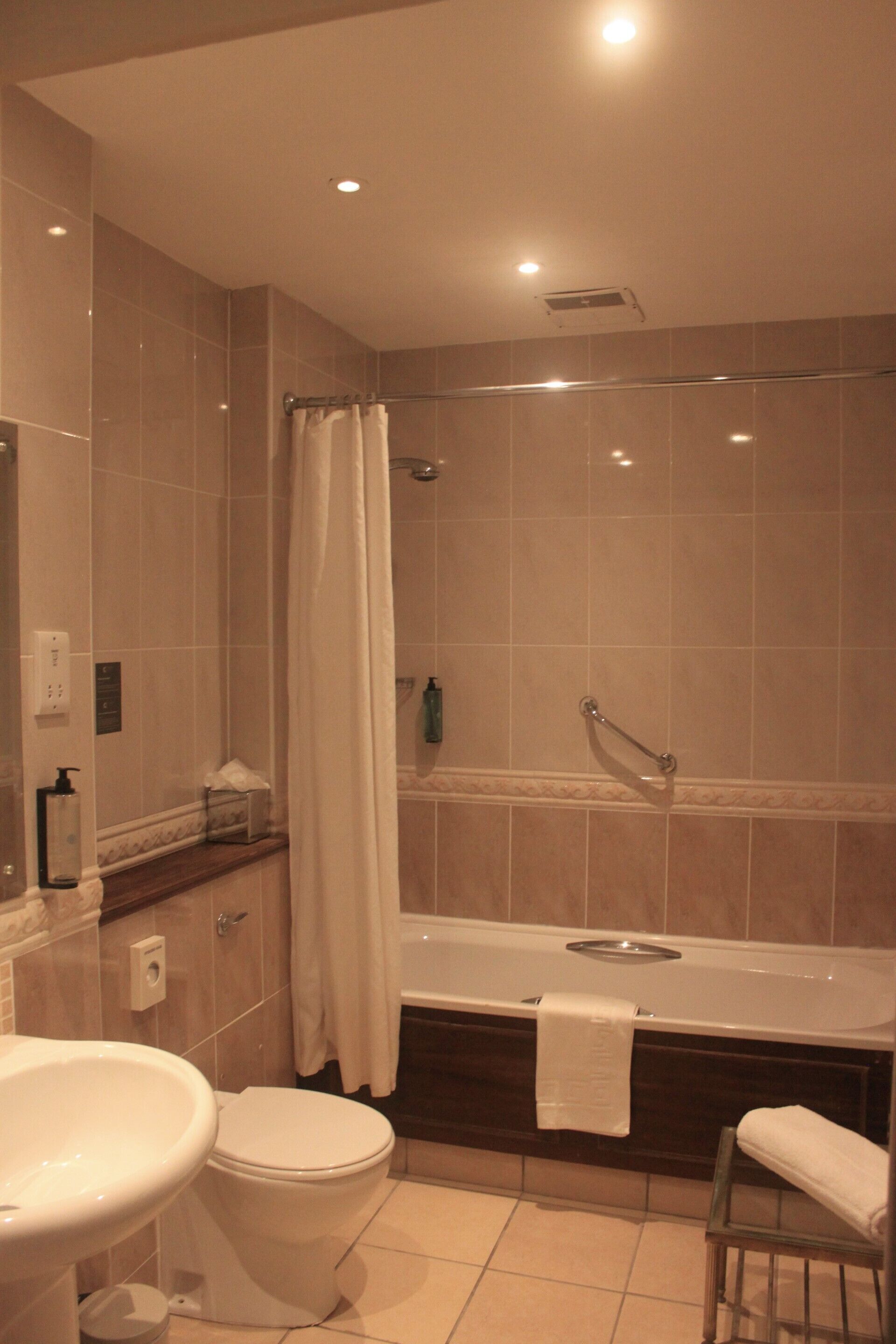 A bathroom with a bathtub, toilet, and sink.