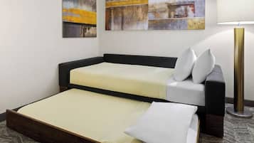 Una cama doble con estructura de madera, una mesita de noche con lámpara y una obra de arte abstracta en la pared.